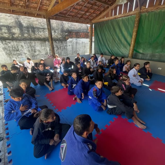 Turma do HOS Jiu-Jitsu sentada no tatame durante o treino